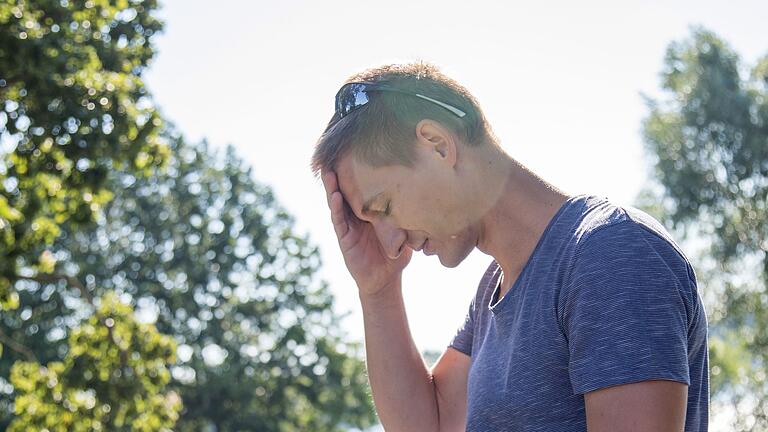 Mann mit Kreislaufproblemen       -  Starke Kopfschmerzen und Schwindel? Das kann auf einen Sonnenstich hindeuten. Auch ein hochroter, heißer Kopf ist ein Anzeichen.