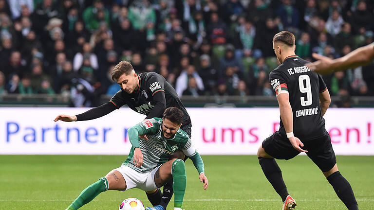 Werder Bremen - FC Augsburg.jpeg       -  Werders Leonardo Bittencourt kämpft gegen Augsburgs Elvis Rexhbecaj und Ermedin Demirovic (rechts) um den Ball.