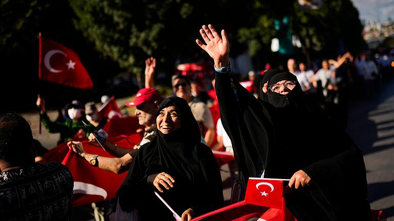 Jahrestag des gescheiterten Putschversuchs in der Türkei       -  Menschen halten türkische Flaggen hoch, während sie sich zu Ehren der Opfer des gescheiterten Putschversuchs vom 15. Juli 2016 versammelten. (Archivbild)
