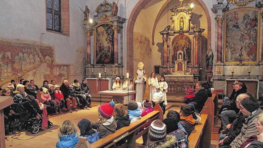 Fest des heiligen Nikolaus       -  (gab)   Nikolaus von Myra (Demre) ist einer der bekanntesten Heiligen der Ostkirchen und der lateinischen Kirche. Sein Gedenktag, der 6. Dezember, wird in vielen Kirchen begangen. Nikolaus wirkte in der ersten Hälfte des vierten Jahrhunderts als Bischof von Myra in Lykien (Kleinasien), damals Teil des römischen, später des byzantinischen Reichs, heute der Türkei. Der Gedenktag des Heiligen ist mit vielen Bräuchen verbunden, wie dem der Befragung der Kinder, ob sie brav und fromm gewesen seien, oder dem nächtlichen Füllen der Schuhe. Ursprünglich war der Nikolaustag auch der Tag der Weihnachtsbescherung. Erst nach der Reformation wurde die Bescherung auf Weihnachten verlegt und das Christkind löste Nikolaus als Gabenbringer ab. Das Bild entstand in der Spitalkirche in Karlstadt.