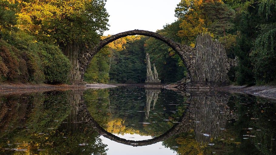 Flitterwochen in Deutschland       -  Im Azaleen- und Rhododendronpark Kromlau ist die Rakotzbrücke zu finden. Sie spiegelt sich im davorliegenden See und ergibt einen perfekten Kreis.