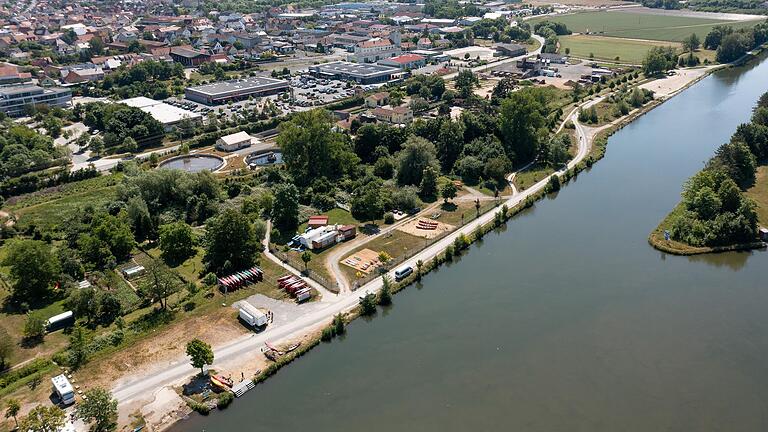 Blick von oben auf die Volkacher Mainlände. Zu sehen sind der Wohnmobil-Stellplatz (links vorne) und die Anlegestelle des Kanuverleihs. Die neue Planung der Mainlände soll weiter Richtung Süden (rechts) reichen, über den Kanuverleih Waterwalker hinaus.
