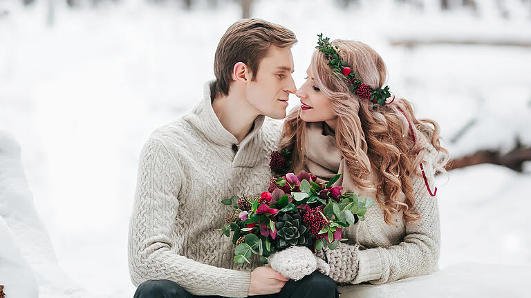 Bride and groom in winter forest. Moment before a kiss. Artwork       -  Nicht ist romantischer als eine Traaung in der besinnlichsten Zeit des Jahres. Doch gerade dann gibt es einige Herausforderungen zu bewältigen - besonders bei der Terminfindung.