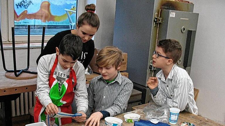 Workshop: Auf den Spuren von Fossilien       -  (svk)   An einem jahrgangsübergreifenden Fossilienworkshop haben die vierten Klassen der Nikolaus-Fey-Schule teilgenommen: Organisiert und geleitet wurde der von Ulrike Sandmeyer-Haus vom Gymnasium Steigerwald Landschulheim &ndash; Tutoren aus der achten und neunten Jahrgangsstufe haben sie dabei unterstützt, teilt die Schule mit. Zunächst lernten die Schüler, wie Fossilien entstehen und schauten sich echte Stücke aus der geologischen Sammlung des Steigerwald Landschulheims an. Anschließend stellten sie mit Gips Abdrücke von Muschelschalen her, um den natürlichen Entstehungsprozess von Fossilien nachvollziehen zu können, heißt es in der Mitteilung weiter. Die einzelnen Arbeitsschritte wurden von den Tutoren des Steigerwald Landschulheims angeleitet, die dadurch ihr Fachwissen und soziale Kompetenzen festigen konnten &ndash; so auch Katharina Stark, die hier mit den Viertklässlern (von links) Niklas Löchner, David Fincher und Julius Kober zusammenarbeitet.