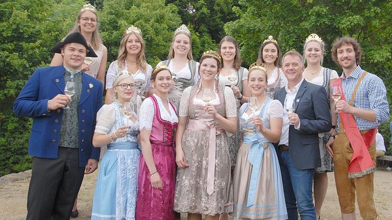 Hofstaat mit Königin: Zahlreiche Weinprinzessinnen und die Weinprinzen Peter Hartmann (rechts) aus Possenheim und Carol Feilitzsch (vorne links) aus Gaibach lächeln zusammen mit der 65. Fränkischen Weinkönigin Eva Brockmann (hinten links) in die Kamera.