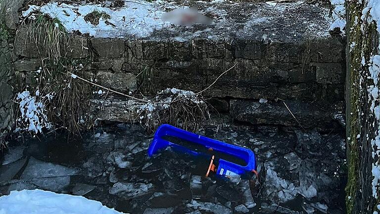 Der blaue Bob des verunglückten Jungen liegt im Eiswasser.