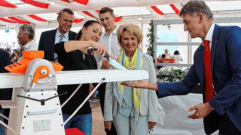 Die erste international erfolgreiche Fritsch-Maschine, die Rollfix, in Kuchenform. Auf dem Foto schneidet Anna-Maria Fritsch den Kuchen an, rechts ihr Vater Klaus Fritsch. Es assistierten (von links) Kitzingens Oberbürgermeister Siegfried Müller, Jan Fritsch und Landrätin Tamara Bischof.