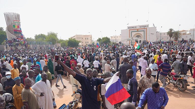 Putsch im Niger.jpeg       -  Ein Demonstrant hält eine russische Nationalfahne, während er an einem Marsch teilnimmt, zu dem Anhänger des Putschisten General Omar Tchiani aufgerufen haben.