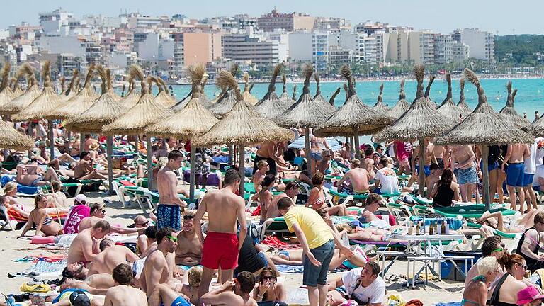 Touristen auf Mallorca       -  Urlauber tummeln sich am Strand von Arenal auf der Mittelmeerinsel Mallorca.