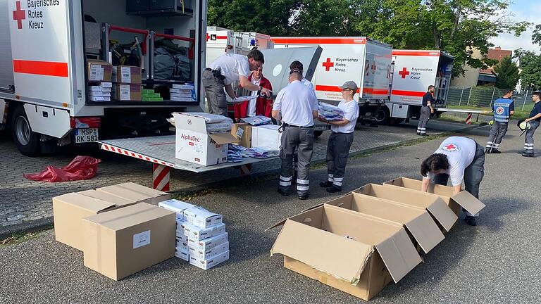 Karlstadter Einsatzkräfte entladen mitgebrachte Schutzbekleidung aus ihrem Gerätewagen zur weiteren Verteilung an die Helferinnen und Helfer in der Region. Karlstadter Einsatzkräfte entladen mitgebrachte Schutzbekleidung aus ihrem Gerätewagen zur weiteren Verteilung an die Helferinnen und Helfer in der Region.