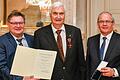 Staatsekretär Gerhard Eck (links) und Regierungspräsident Eugen Ehmann (rechts) verleihen den&nbsp;Verdienstorden der Bundesrepublik Deutschland&nbsp;an Dr. Peter Rost aus Randersacker.