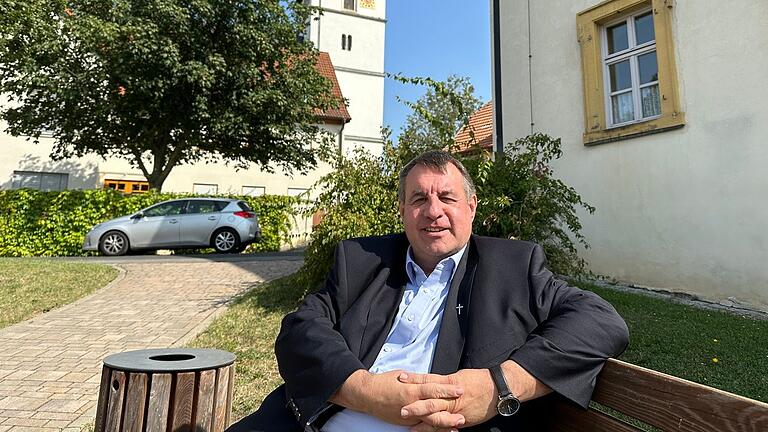 Vor seinem Pfarrhaus in Großeibstadt hat der neue Pfarrer Jürgen Schwarz einen idyllischen Platz mit Blick auf Marienstatue und Kirche.&nbsp;