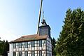 Zwei Arbeiter bringen in schwindelnder Höhe die Turmkrone auf dem Kirchlein in Weimarschmieden wieder sturmfest an.