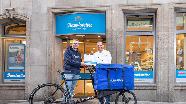 Radboten liefern Bestellungen aus dem Brandstetter Online-Shop aus       -  Geschäftsführer Christian Englert vom Marktcafé Brandstetter übergibt Danny Linke, Leiter der Radboten eine frische Lieferung mit Backwaren.