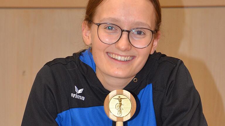 Stolz präsentiert Barbara Gold den an sie überreichten Holzpokal.