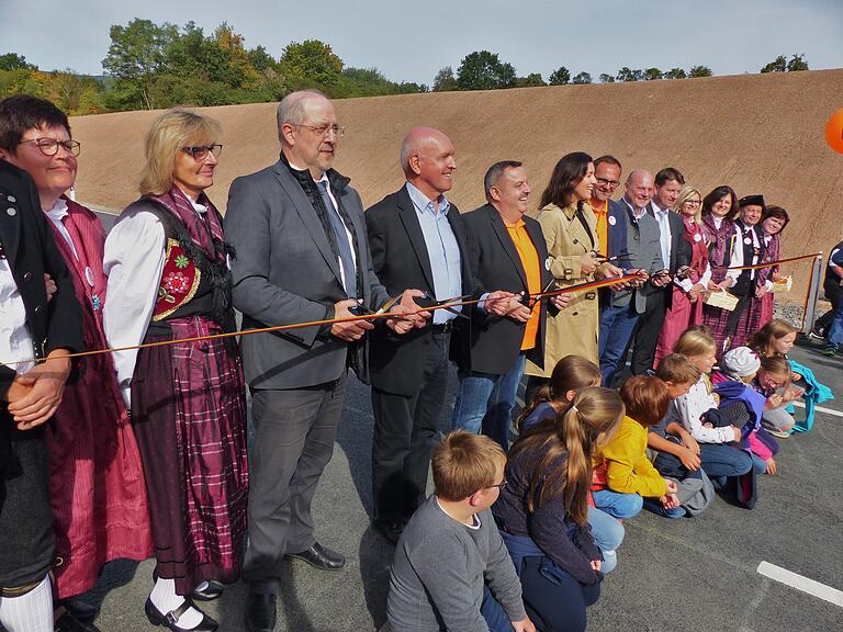 Mit dem Durchschneiden des Bandes und der Unterstützung durch das Daanzgesindel und den Kindern des Kindergartens wurde die Ortsumgehung Wegfurt für den Verkehr freigegeben. Ab 3. von links: Dr. Michael Fuchs (Amtsleiter Staatliches Bauamt), Landrat Thomas Habermann, Andreas Griebel (Sprecher UmWeg), Staatsministerin Dorothee Bär, Klaus Kleinhenz (Sprecher UmWeg), Bürgermeister Georg Seiffert und Sandro Kirchner (MdL).