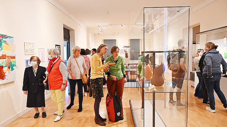 Besucherinnen und Besucher der Vernissage betrachten sowohl Gemälde als auch Plastiken Besucherinnen und Besucher der Vernissage betrachten sowohl Gemälde als auch Plastiken