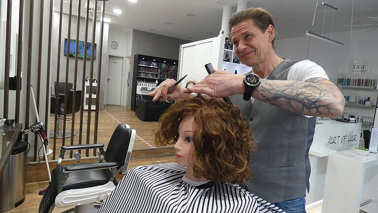 Friseurmeister Oliver Merkl freut sich, bald wieder öffnen zu können. Der Frisierkopf erregte schon in den vergangenen Wochen große Aufmerksamkeit bei Passanten, die in das Schaufenster des 'Team Art of Hair' in der Haßfurter Bahnhofstraße hineinschauten.