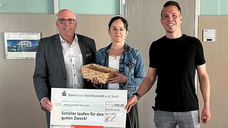 Geld für den Spendenlauf: Sparkassenvorstand Georg Straub, Marketingmitarbeiterin Nicole Büchs und Bastian Reukauf, Geschäftsführer des Arbeitskreises Sport in Schule und Verein.