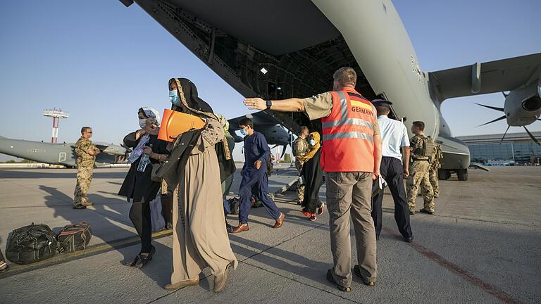 Schutzbedürftige Menschen betreten am 25. August kurz nach dem Flug aus Kabul sicheren Boden in Taschkent (Usbekistan) zum Weiterflug nach Deutschland.