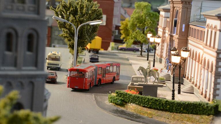 Nicht nur Eisenbahnen gibt es zu sehen, sondern auch LKWs und Autos - oder Busse, wie hier vor dem Bahnhof.