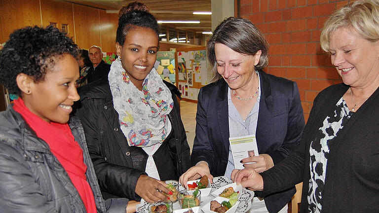 Die Berufsschülerinnen Semrt Chaklu (von links) und Helen Melkomu bieten Berufsschulleiterin Katin Maywald und Fachbetreuerin Doris Peter selbstgemachte Leckereien an. Foto: Sigismund von Dobschütz       -  Die Berufsschülerinnen Semrt Chaklu (von links) und Helen Melkomu bieten Berufsschulleiterin Katin Maywald und Fachbetreuerin Doris Peter selbstgemachte Leckereien an. Foto: Sigismund von Dobschütz