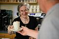 Eine Mitarbeiterin serviert im Café Perspektive am Waldkugelweg in Würzburg einen Cappuccino.