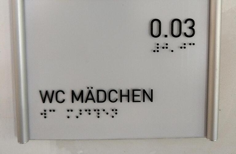 Barrierefreiheit heißt auch Braille-Schrift an den Türschildern öffentlicher Gebäude - wie hier in der&nbsp; Grundschule in Randersacker (Lkr. Würzburg).