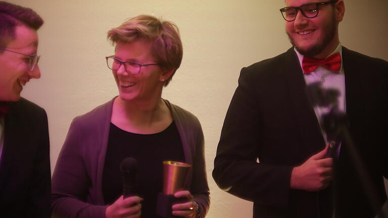 Die Moderatoren Timo Richter und Felix Prechtel beim Neujahresempfang der Evangelischen Jugend im Dekanat Würzburg gemeinsam mit der neuen Dekanatsjugendpfarrerin Susanne Hötzel auf der Bühne.