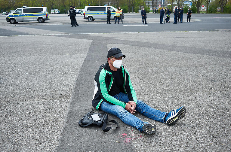 Das Bündnis 'Schweinfurt auf die Straßen SWADS' hatte am Freitag, 30. April, die Veranstaltung auf dem Volksfestplatz für den 1. Mai kurzfristig abgesagt. Dennoch sicherte die Polizei das Gelände und vereinzelt kamen Menschen vorbei, wie dieser Mann, dessen Protest die Polizei zuließ.