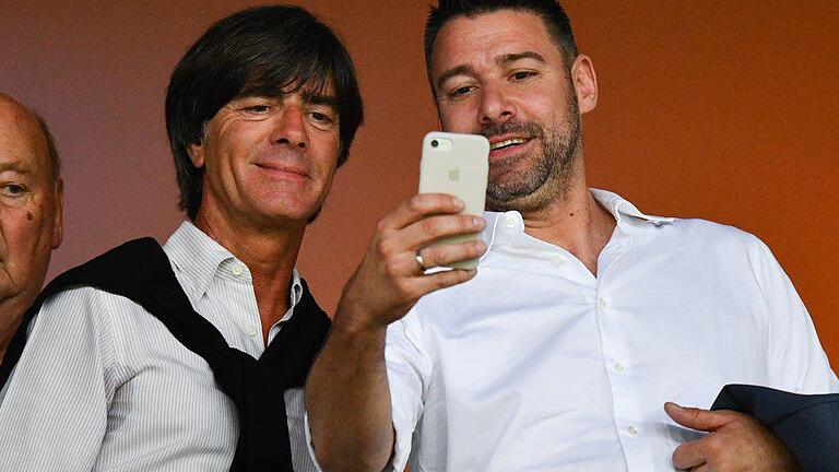 Zuschauer       -  Bundestrainer Joachim Löw (l) posiert bereitwillig auf der Tribüne für ein Selfie. Foto: Uwe Anspach