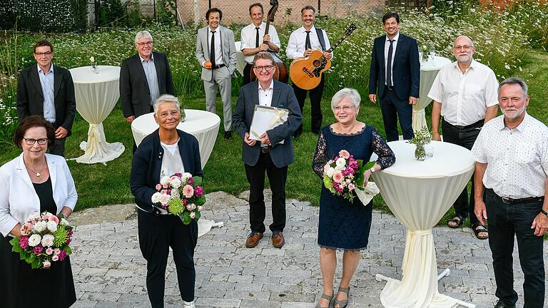 Verabschiedung ehemaliger Gemeinderäte in Höchberg mit Bürgermeister Alexander Knahn (Dritter von rechts) und den Geehrten (vordere Reihe von links): Magdalena Roßbach, Jutta Schulz, Doris Strauch, Frank Rothbächer; (hintere Reihe von links): Markus Linsenmeyer, Bernhard Hupp, Günter Klopf und Berthold Friedrich. Im Hintergrund die Band-Mitglieder von 'Boogie Pilots'.