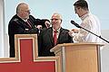 Michael Behringer (Bezirksbereitschaftsleiter, links) bringt zusammen mit dem Leiter des Wahlausschusses Alexander Kretz (rechts), die Amtsinsignien beim gewählten Kreisbereitschaftsleiter Burkard Kühn an.       -  Michael Behringer (Bezirksbereitschaftsleiter, links) bringt zusammen mit dem Leiter des Wahlausschusses Alexander Kretz (rechts), die Amtsinsignien beim gewählten Kreisbereitschaftsleiter Burkard Kühn an.