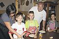 Pizza machen ist nicht schwer       -  (schd)   Pizza essen kann jeder, Pizza selber machen ist zwar schwerer, aber seit dem jüngsten Ferienspaß für einige Grafenrheinfelder Kinder auch kein Problem mehr. Das Angebot war eine Premiere, erstmalig beteiligte sich Tiziano Marcato, Besitzer der Grafenrheinfelder Pizzeria Ai Due Galli am gemeindlichen Ferienspaßprogramm mit durchschlagendem Erfolg, denn das Angebot war in Sekunden ausgebucht und Tizi, wie er im Rafelder Volksmund eigentlich nur genannt wird, freundlicherweise bereit, einen zweiten Kurs anzubieten. In seiner urigen Scheune wurde also nun in zwei Durchgängen eifrig geknetet und gerollt und das teigige Ergebnis dann wie im Foto in Form gepresst und mit allem belegt, was das Herz begehrt und der eigene Magen gerne mag. Die klassischen Hauptbestandteile waren natürlich der Teig mit Tomate, garniert wahlweise ganz nach &bdquo;Gusto&ldquo; mit Käse, Pilzen, Schinken und Salami. Und da so eine kleine hungrige Rasselbande nicht ganz ohne Hilfe zu bändigen war, halfen einige Mütter mit, wahrscheinlich nicht ohne selbst den einen oder anderen Tipp zum Pizzabacken mit nach Hause zu nehmen.
