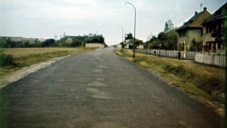 Blick von der Rottendorfer Straße (damals Ludendorffstraße) auf den mit Schlagbaum und Zaun abgesperrten Fliegerhorst. Auf dem Dia von 1943 ist links vom Zugang ein alter Bildstock zu erkennen, der sich noch heute hier befindet; rechts stehen Häuser der nach dem Ersten Weltkrieg errichteten sogenannten Kriegersiedlung.