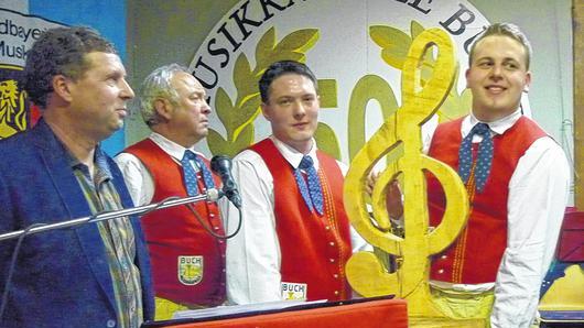 Geschenk von den Bierbrauern: Zwei Hektoliter Gerstensaft und einen hölzernen Notenschlüssel nahm die Blaskapelle Buch bei Kommersabend am Samstag in Empfang.