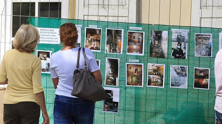 Am Bauzaun sind Fotos vom Brandtag 16. Mai 2016 angebracht &ndash; stumme Zeugen einer Katastrophe. Am Pfingstmontag 2016 waren die Innenräume des Erdgeschosses und ersten Stockes weitgehend zerstört worden.