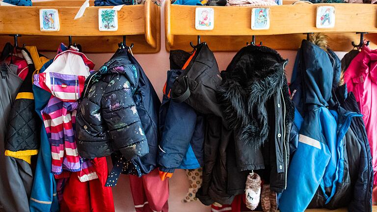 Symbolbild: Kinderjacken und Rucksäcke hängen an der Garderobe in einer Kita.