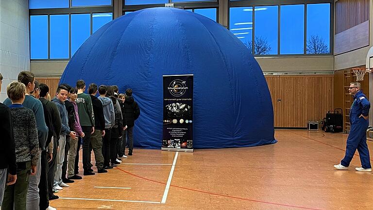 RealschülerInnen beim Eintreten ins Planetarium, rechts Astrophyysiker Tilo Hohenschläger.