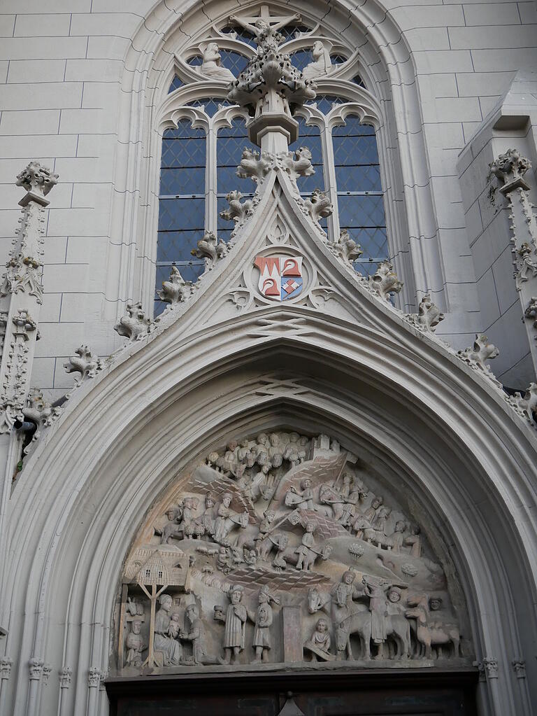 Das Portal der Haßfurter Ritterkapelle zeigt die Anbetung der Heiligen drei Könige. Darüber ist das Stifterwappen Johanns von Brunn zu sehen.&nbsp;