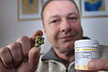Würzburger bekommt Cannabis auf Rezept       -  Günter Weiglein mit einer getrockneten Cannabisblüte und der dazu gehörigen Medizindose.
