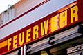 Feuerwehr       -  Auf dem Einsatzfahrzeug ist in gelber Farbe der Schriftzug &bdquo;Feuerwehr&rdquo; zu lesen.