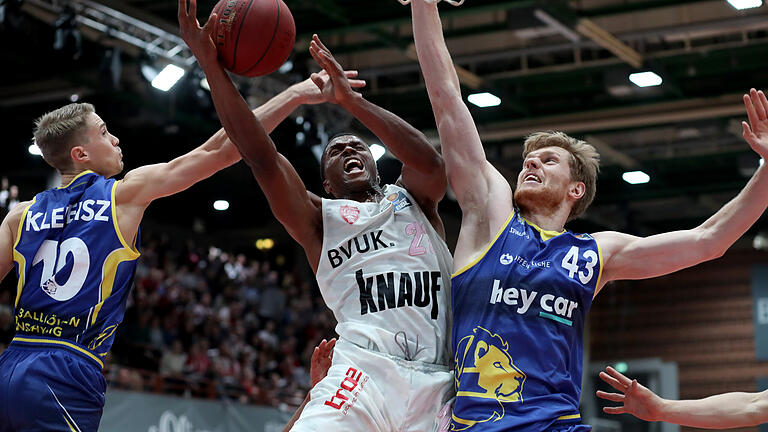 Ein Bild aus der Vorsaison: Der Würzburger Cameron Wells (Mitte) im Duell mit dem Braunschweiger Scott Eatherton (rechts). Ein Bild aus der Vorsaison: Der Würzburger Cameron Wells (Mitte) im Duell mit dem Braunschweiger Scott Eatherton (rechts).