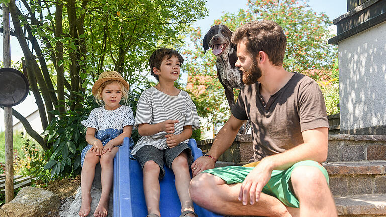 Amelie, Noah und Familienhund Muck genießen den Sommer mit Papa Frank Vierheilig in ihrem Garten in Waldbüttelbrunn. Foto: Thomas Obermeier Amelie, Noah und Familienhund Muck genießen den Sommer mit Papa Frank Vierheilig in ihrem Garten in Waldbüttelbrunn. Foto: Thomas Obermeier