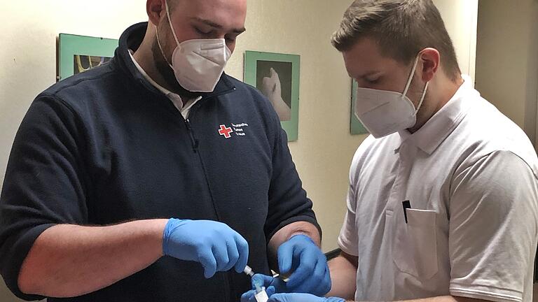 Helferteam aus dem Landkreis Rhön-Grabfeld: Der Impfstoff wird aus der Kühlbox genommen, mit Kochsalzlösung verdünnt und in die Spritze aufgezogen. Helferteam aus dem Landkreis Rhön-Grabfeld: Der Impfstoff wird aus der Kühlbox genommen, mit Kochsalzlösung verdünnt und in die Spritze aufgezogen.