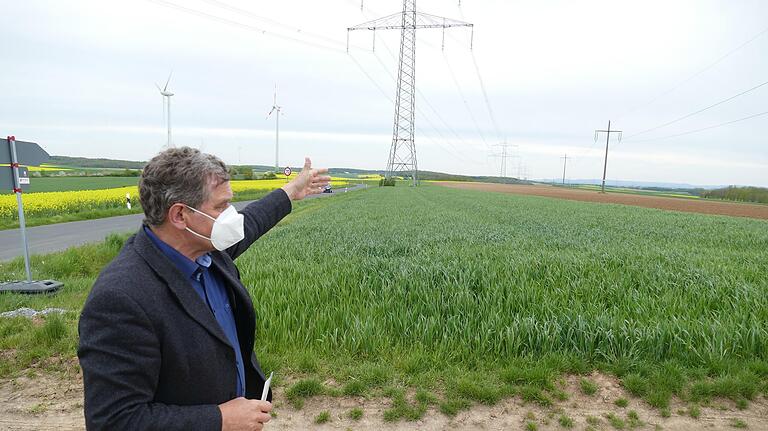 Arnsteins Bürgermeister Franz-Josef Sauer zeigt auf der 'Schraudenbacher Höhe' die gegenwärtige Stromversorgung mit Windrädern, Solaranlagen und großen Überlandleitungen auf.&nbsp;