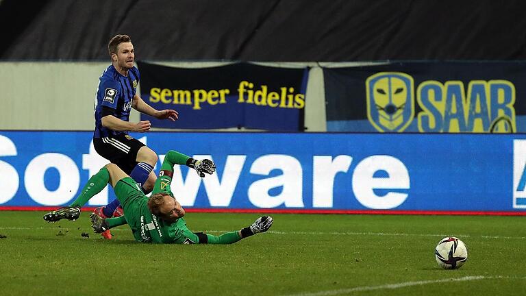 Nach einem eigentlich harmlosen Ball in Richtung Strafraum eilt Kickers-Torhüter Hendrik Bonmann (liegend) zu weit aus seinem Kasten heraus und tritt am Spielgerät vorbei. Saarbrückens Sebastian Jacob schiebt zum 2:1 ein.