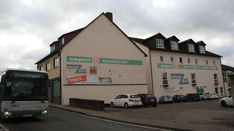 Auf dem Tegut-Parkplatz in der Schallfelder Straße in Gerolzhofen, rechts neben der Mauer, wo das weiße und das dunkle Auto stehen (Bildmitte), soll eine Schnellladestation für Elektro-Fahrzeuge entstehen.
