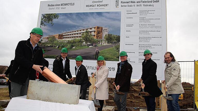 Grundsteinlegung an der Baugrube für das neue Sonnenhotel in Volkach: Bauleiter Werner Weipert steckt die Zeitkapsel in das Betonfundament. Architekt Manfred Stockinger, Weinbaupräsident Artur Steinmann, Bürgermeister Peter Kornell, Landrätin Tamara Bischof und Investor Peter Heidecker (von rechts) machen den symbolischen Spatenstich.