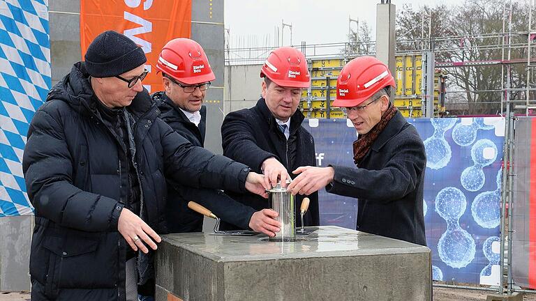Die Zeitkapsel wird in einem Betonblock versenkt (v. li.): THWS-Vizepräsident Prof. Martin Naumann, Stephan Kranig (Vorstand der Riedel Bau Gruppe), Sandro Kirchner (Staatssekretär im Bayerischen Ministerium des Inneren) und der Schweinfurter Oberbürgermeister Sebastian Remelé. Die Zeitkapsel wird in einem Betonblock versenkt (v. li.): THWS-Vizepräsident Prof. Martin Naumann, Stephan Kranig (Vorstand der Riedel Bau Gruppe), Sandro Kirchner (Staatssekretär im Bayerischen Ministerium des Inneren) und der Schweinfurter Oberbürgermeister Sebastian Remelé.